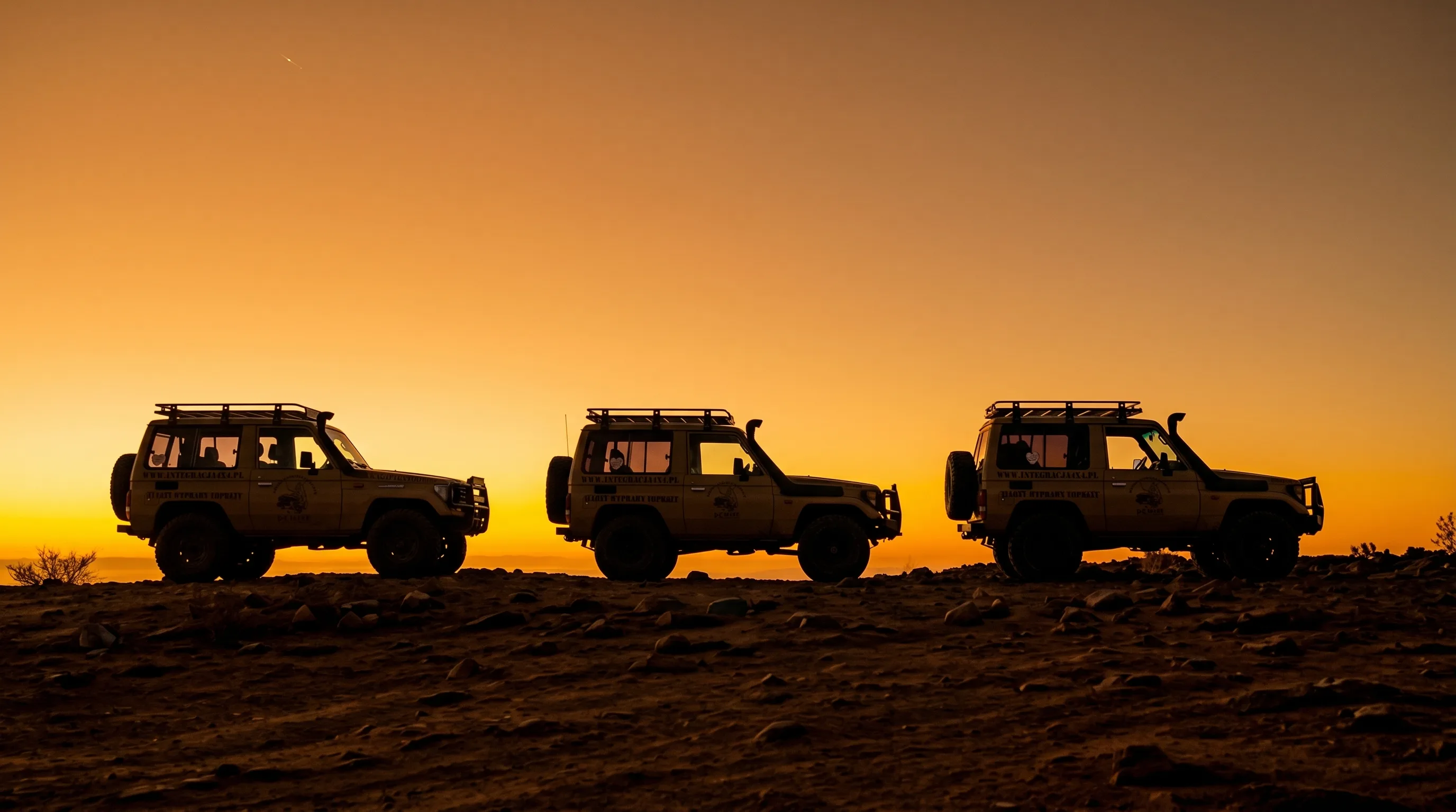 Pojazdy terenowe 4x4 na szczycie wzgórza o zachodzie słońca – Integracja4x4